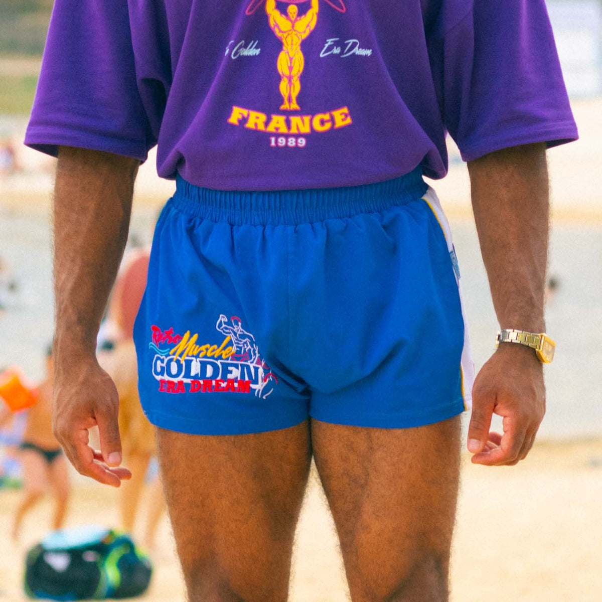 Short de bain Golden Era Dream porté dans une scène de plage Purple World
